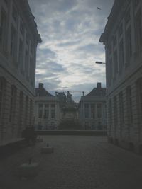 Buildings in city against cloudy sky