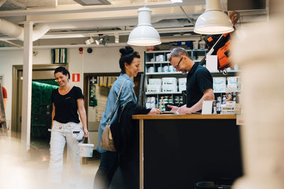 Smiling salesman assisting customer at hardware store