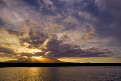 Scenic view of sea against dramatic sky during sunset