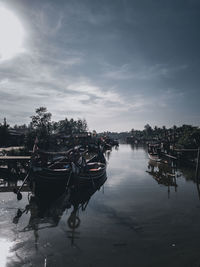 Boats moored in canal against sky