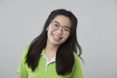 Portrait of smiling young woman against white background