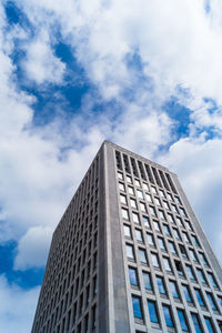 Low angle view of modern building against cloudy sky