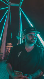 Portrait of young man wearing sunglasses at night