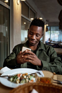 Portrait of young woman having food at restaurant