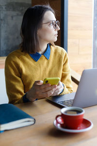 Woman using laptop while sitting on chair