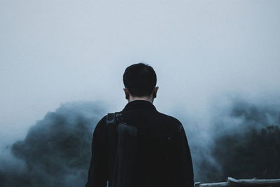 Rear view of a silhouette man against sky