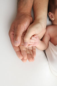 Cropped image of baby on bed