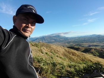 Portrait of man standing on mountain against sky