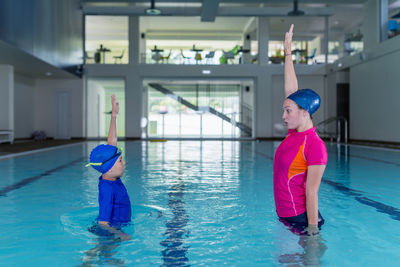 Mother teaching swimming to son in pool