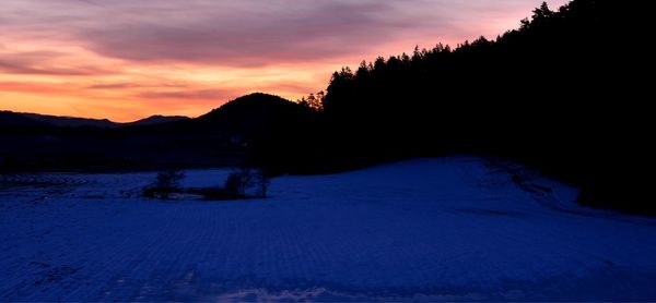 Scenic view of snowcapped mountains against sky during sunset