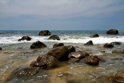 Rocks on beach against sky