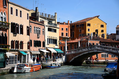 Boats in canal amidst buildings in city