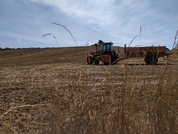 Tractor on agricultural field against sky