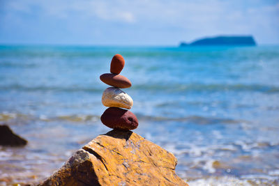 Close-up of rock on beach against sky