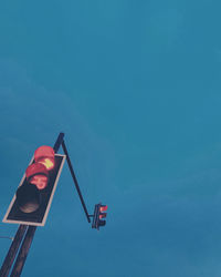 Low angle view of road signal against blue sky