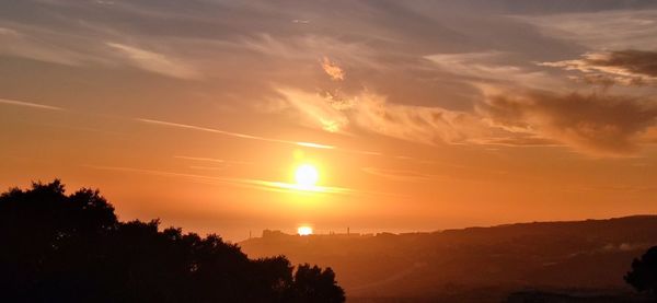 Scenic view of silhouette trees against romantic sky at sunset