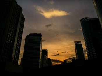 Skyscrapers against sky during sunset