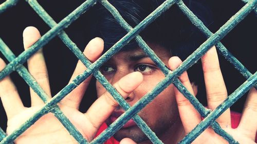 Portrait of man seen through fence