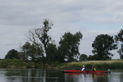 People in lake against sky