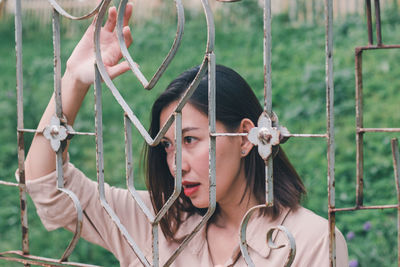 Woman looking away through railing 