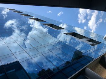 Low angle view of glass building against sky