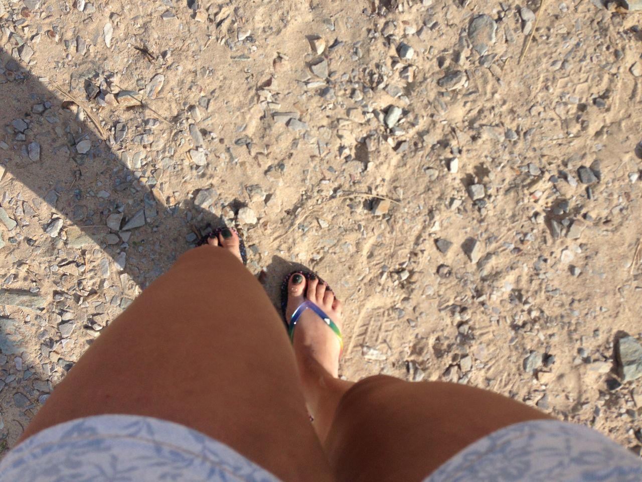 low section, person, personal perspective, lifestyles, leisure activity, human foot, high angle view, barefoot, standing, beach, men, sand, shoe, day, relaxation, sunlight