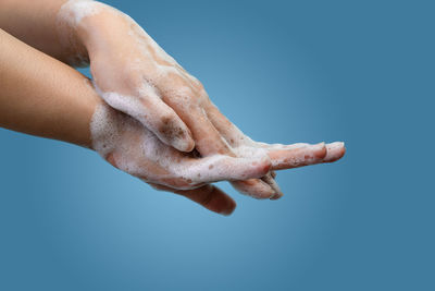 Close-up of hand against blue background