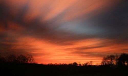 Scenic view of silhouette landscape against orange sky