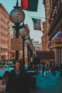 Portrait of man on street against buildings in city