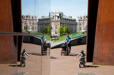 People riding bicycle on road in city