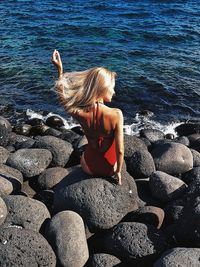 Woman sitting on rock at beach