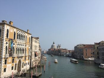 Sailboats in city against clear sky