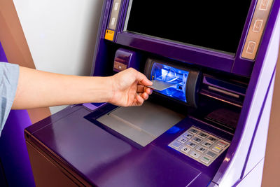 Cropped hand inserting debit card in atm