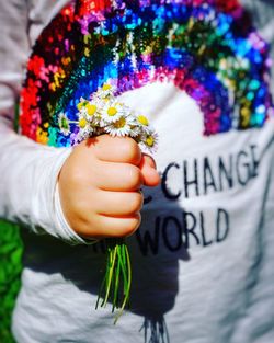 Midsection of boy holding flower bouquet