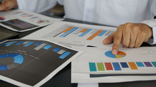 Midsection of business colleagues working on table