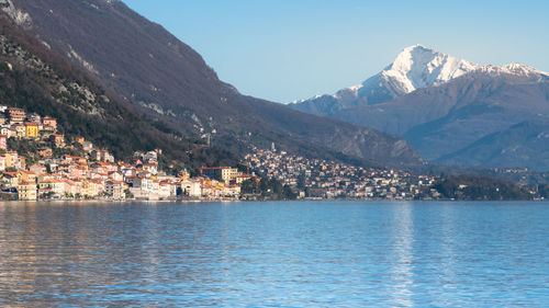 Town by sea and mountains against sky