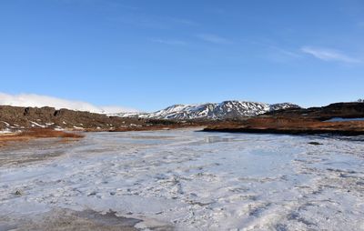 Scenic view of snowcapped mountains against blue sky