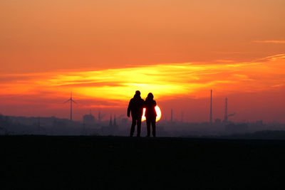 Silhouette people walking at sunset