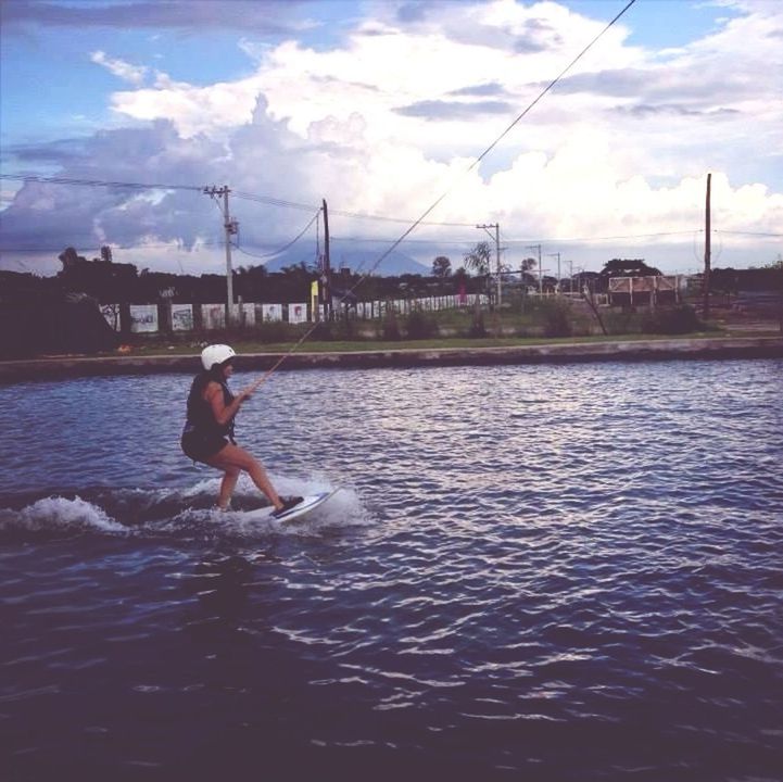 water, sky, cloud - sky, cloud, waterfront, rippled, lifestyles, leisure activity, rear view, cloudy, sea, lake, full length, men, nature, animal themes, river, building exterior