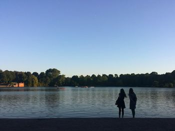 Calm lake against clear sky