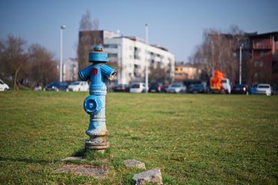 Traditional blue water pump with cityscape in background