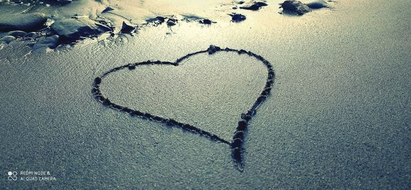 High angle view of heart shape on sand