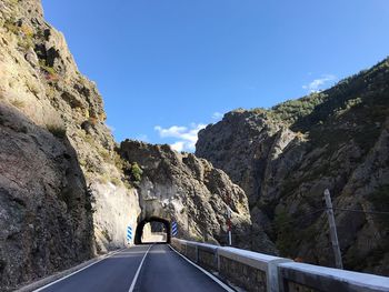 Road amidst rocks against sky