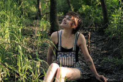 Happy woman sitting in forest