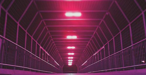 Low angle view of illuminated street lights at night