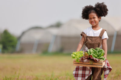 Portrait of smiling woman holding food on field