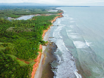 Beach view from the air with beautiful blue sea and beautiful green forest on indonesian coast