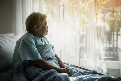 Female senior patient relaxing on bed in hospital