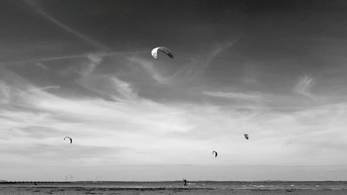 Hot air balloons flying over sea against sky