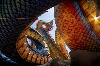  low angle twin stucco painted as a large serpent at pra kai keaw wang nakin,  udon thani, thailand.